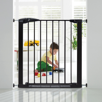 A child playing behind a Munchkin baby gate