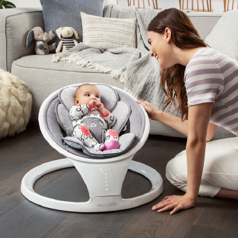 A mother and baby sitting in a Munchkin Baby Swing